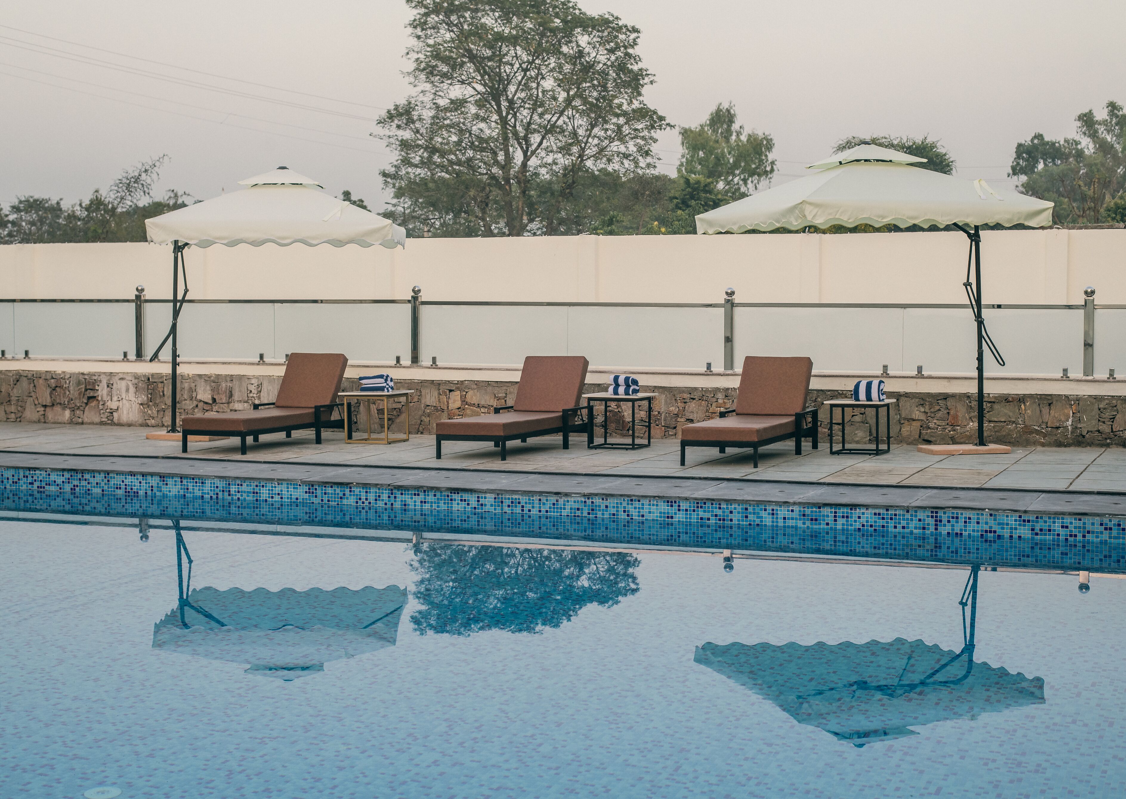 A poolside area with lounge chairs and umbrellas.