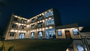 Un edificio de varios pisos con ventanas iluminadas y un césped bien cuidado.