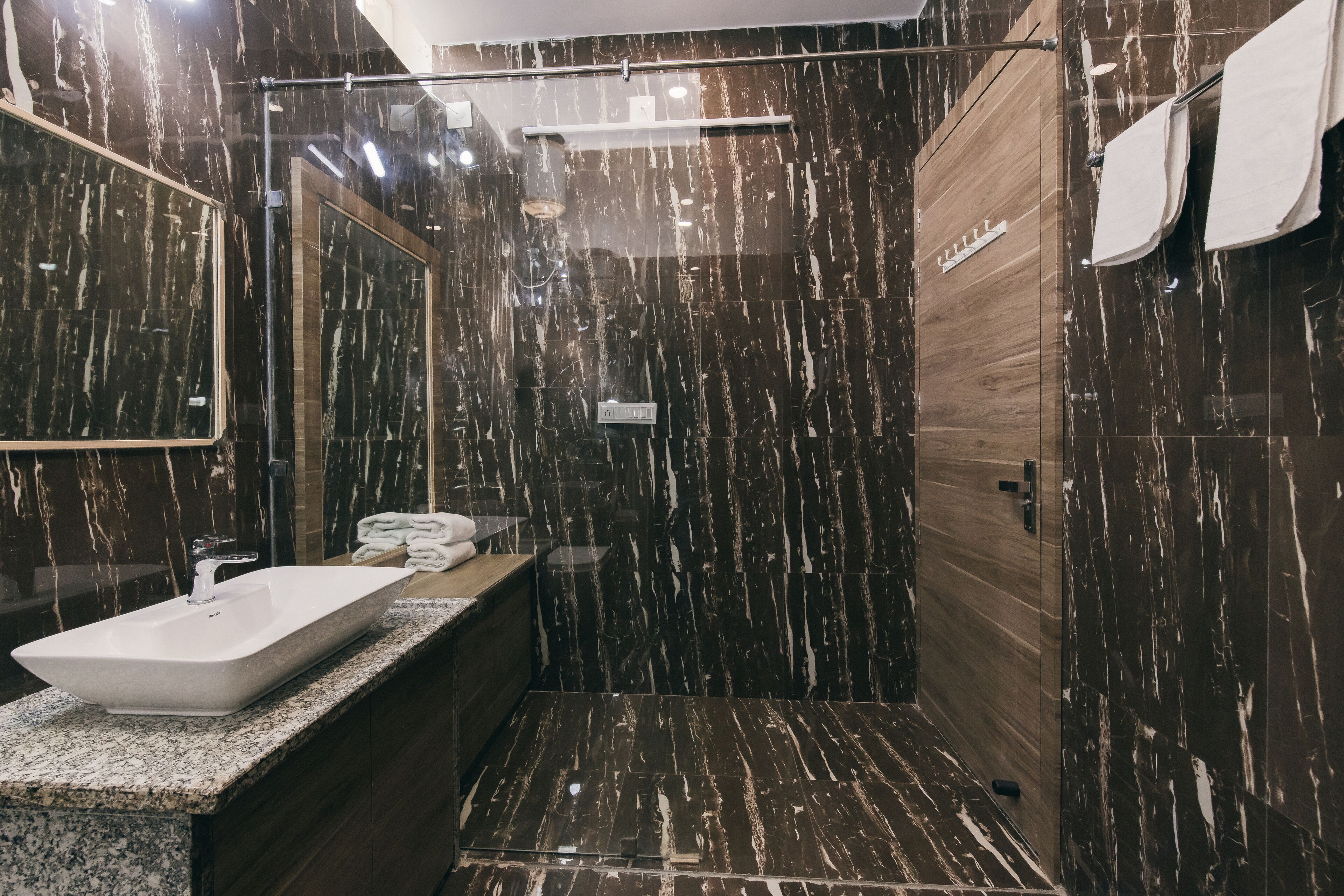 Une salle de bain moderne avec un grand lavabo, un miroir et un espace douche.
