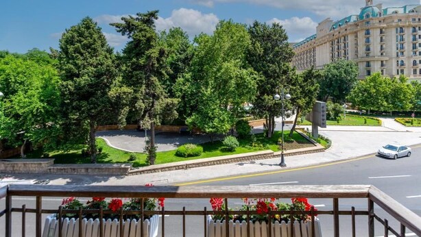 Un hôtel doté d’un grand bâtiment et d’une végétation luxuriante.