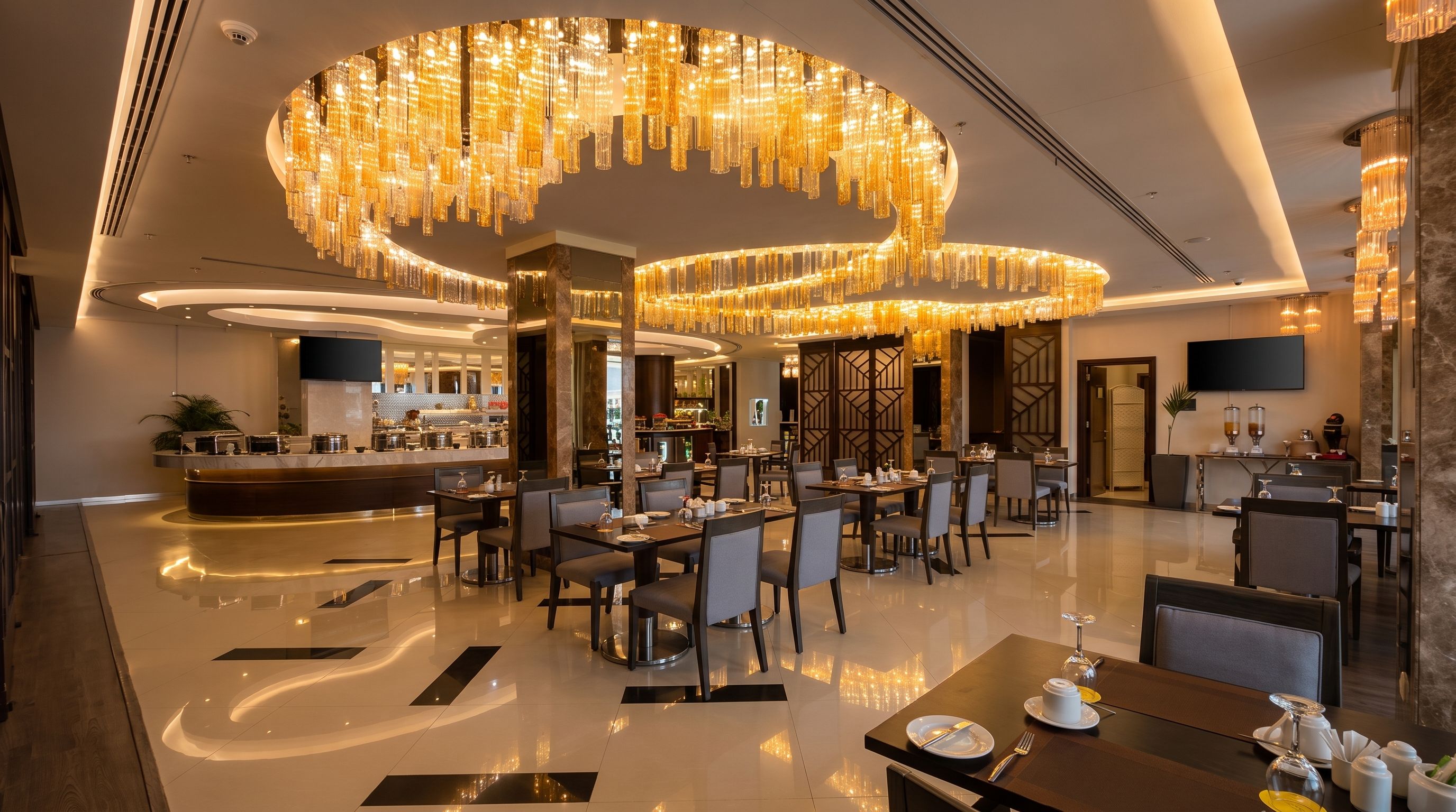 Un moderno vestíbulo de hotel con una zona de bar central, diversas opciones de asientos y candelabros decorativos.