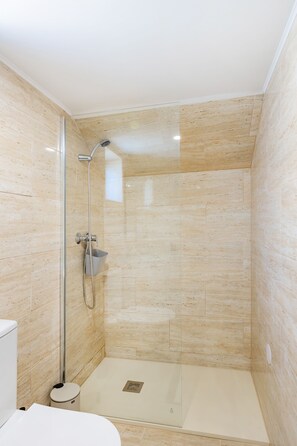 Ein modernes Badezimmer mit einer Duschkabine, einer Toilette und einem Bidet.