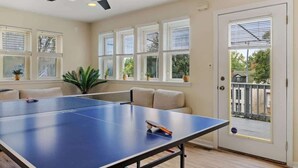 A room with a ping pong table, a ceiling fan, and a door with a view of the outside. - 10 Mins to Downtown, 4BR + Game Room + 3 Baths (Pittsburgh)