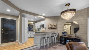 A modern kitchen with a bar area, a large mirror, and a chandelier. - New Listing! Mt. Bachelor Village Condo ~ Views (Bend)