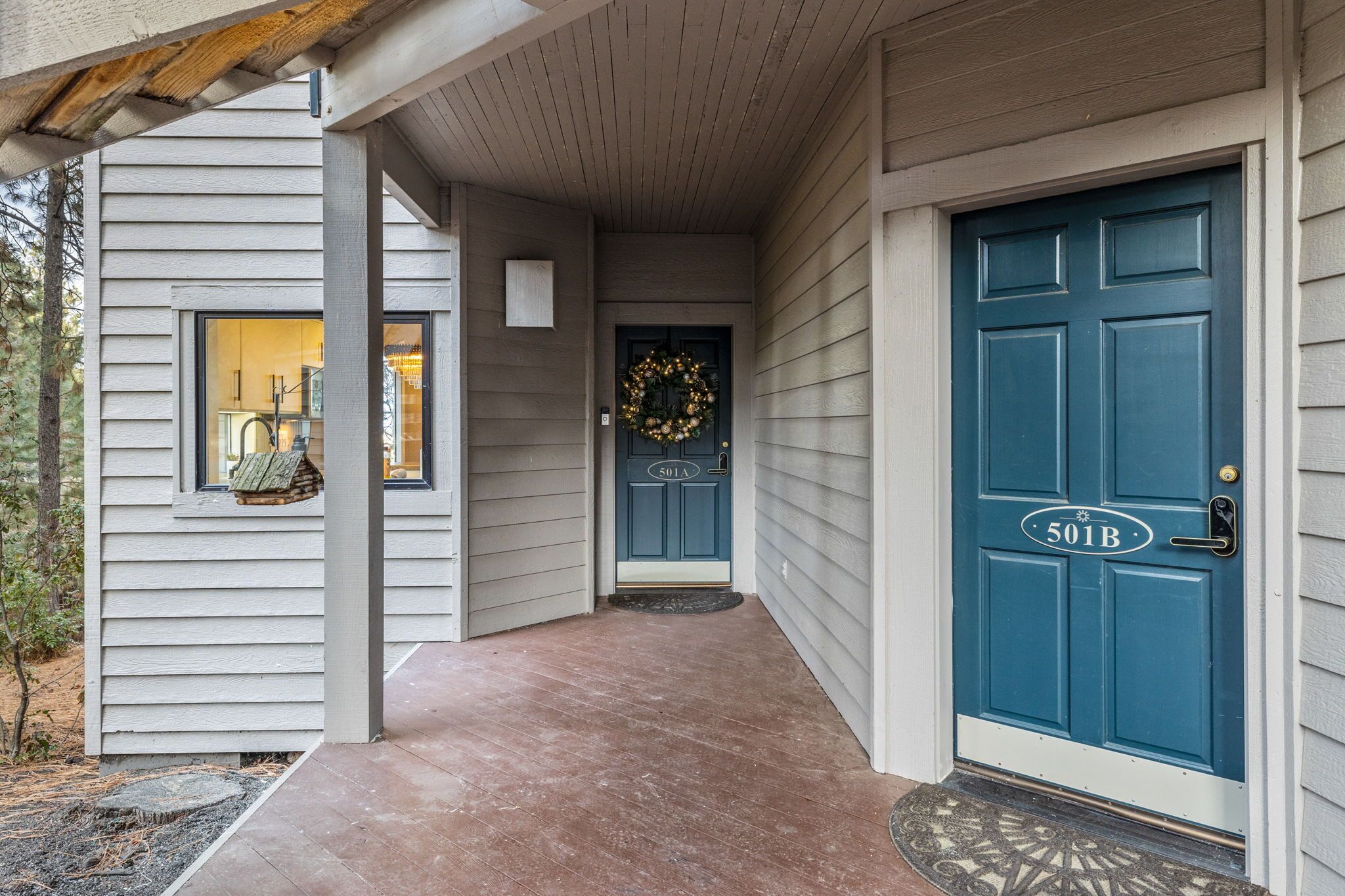 A house with a blue front door, a white exterior, and a covered porch.