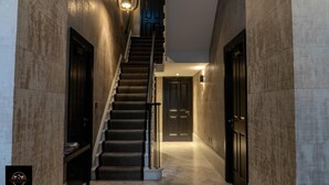 Ein modernes Interieur mit Treppe, einer Bank und einer Tür am Ende.