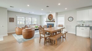 A spacious living room with a large wooden dining table, comfortable seating, and a fireplace.