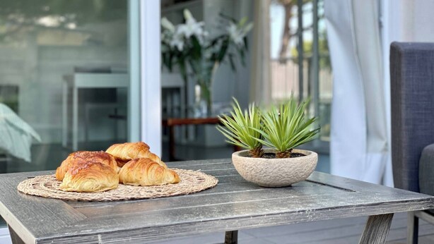 Et bord med croissanter og en potteplante.