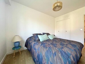 Une chambre à coucher avec un lit, une lampe et une armoire.