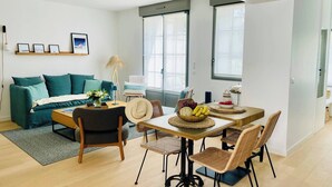 Una sala de estar moderna con un sofá, una mesa de centro y un comedor con sillas.