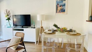 A dining area with a table set for four, a television, a lamp, and a framed picture on the wall. - Appartement La baule "Le 30" (La Baule-Escoublac)