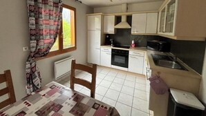 A compact kitchen with white cabinets, a black stove, and a small sink.