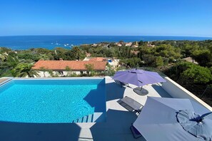 Ein Pool auf dem Dach mit freiem Blick auf das Meer und die umliegenden Gebäude.