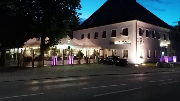 A hotel with a modern design, featuring a large glass facade and a well-lit entrance. - Hotel & Landgasthof Zum Wendelwirt (Germaringen)