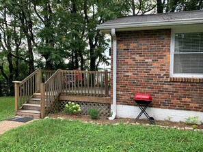 A residential house with a brick exterior, a wooden staircase leading to a deck, and a red barbecue grill. - Avalon 1 mile to downtown and park free (Nashville)