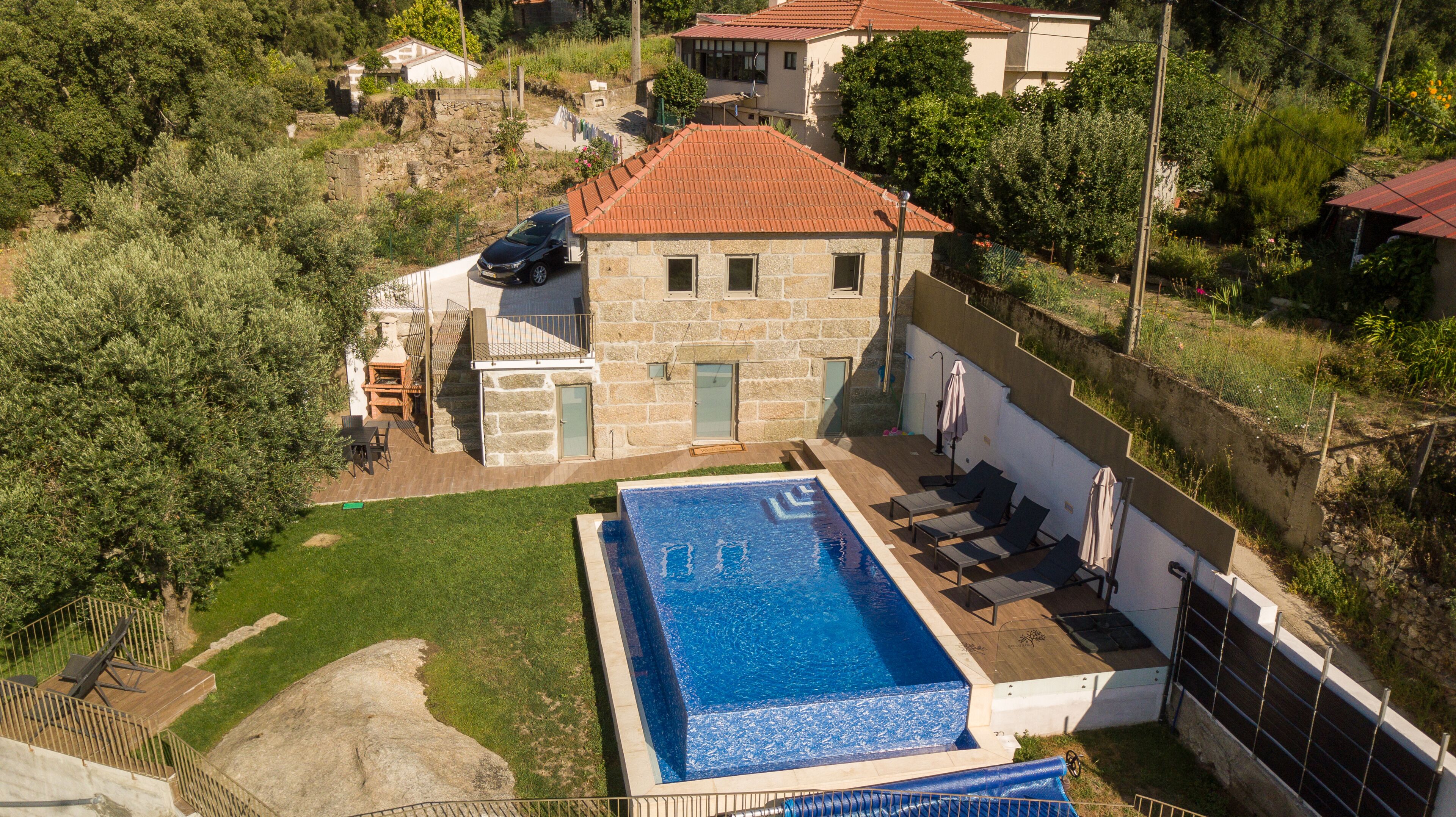 Une maison en pierre dotée d’une piscine, d’un patio et offrant une vue sur le paysage environnant.