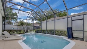 Piscina coberta com teto de vidro, rodeada por piso bege e borda de piscina branca.