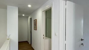 A hallway with wooden flooring, white walls, and white doors. - La casita del Marqués (Alicante)