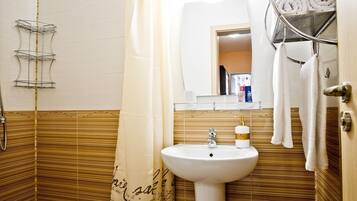 A bathroom with a white sink, a mirror above it, and a towel rack with towels.