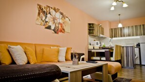 Een woonkamer met een bank, een salontafel en een schilderij aan de muur.