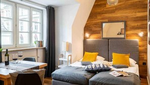 Une chambre à coucher avec un lit, un bureau et une chaise, une fenêtre et un mur en bois.