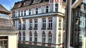 Un immeuble à plusieurs étages de style architectural classique, caractérisé par des fenêtres en arc et des éléments décoratifs.
