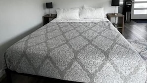 A bedroom with a large bed, a nightstand, a lamp, and a door leading to another room. - Mountain View Retreat Unit 2 - highly rated on leading vacation rental sites! (Mountain View)