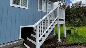 A blue house with a white staircase leading to the front door.