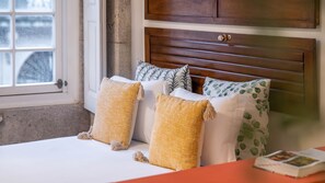 Cozy retreat with a plush bed, adorned with pillows and a bedside book.