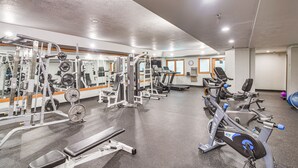 Ein Fitnessstudio mit unterschiedlichen Trainingsgeräten, darunter Kraftgeräte, Laufbänder und Hantbikes.
