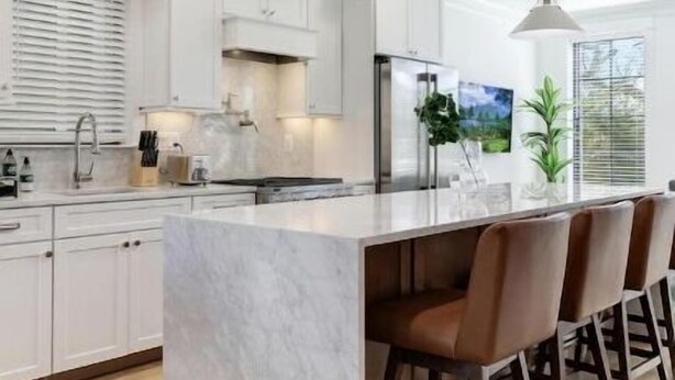 A modern kitchen with white cabinetry, a marble island, and pendant lighting. - Newly Built 3BR Home in Alexandria-Walk to Metro!

 (Alexandria)