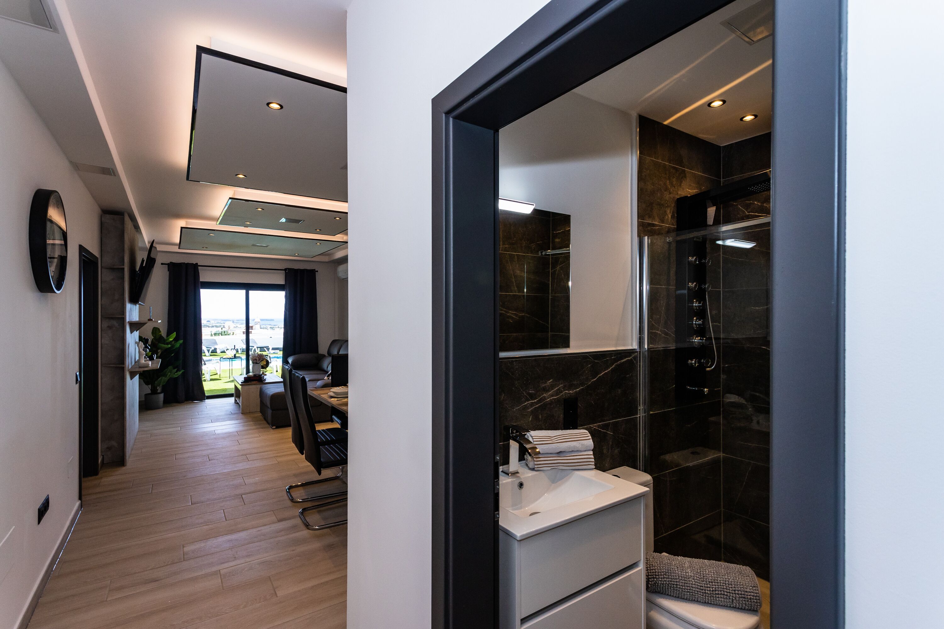 A modern bathroom with a shower, a toilet, and a sink.