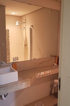 A bathroom with a sink, mirror, shower, and towel rack. - Residencial Don Vito (Capao da Canoa)