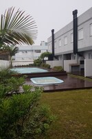 Un patio con piscina, rodeado de vegetación y edificios modernos.