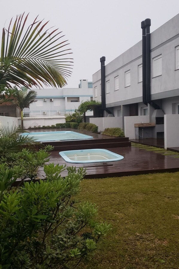 Un patio con piscina, rodeado de vegetación y edificios modernos.