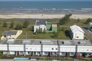 A coastal hotel with multiple buildings, including a large white structure with a flat roof and several smaller buildings with green roofs. - Residencial Don Vito (Capao da Canoa)