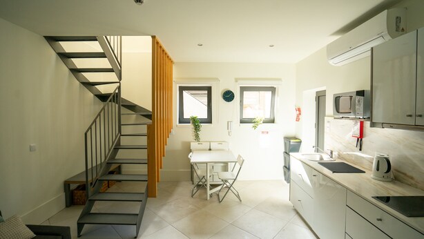 Una cocina moderna con comedor, una escalera y un microondas.