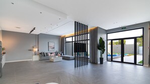 A spacious lobby with a modern sofa set, a large potted plant, and a view of the outdoors through a glass door. - Riyadh View Resort (Riyadh)
