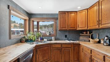 Una cocina con armarios de madera, un ventanal y vistas al exterior.