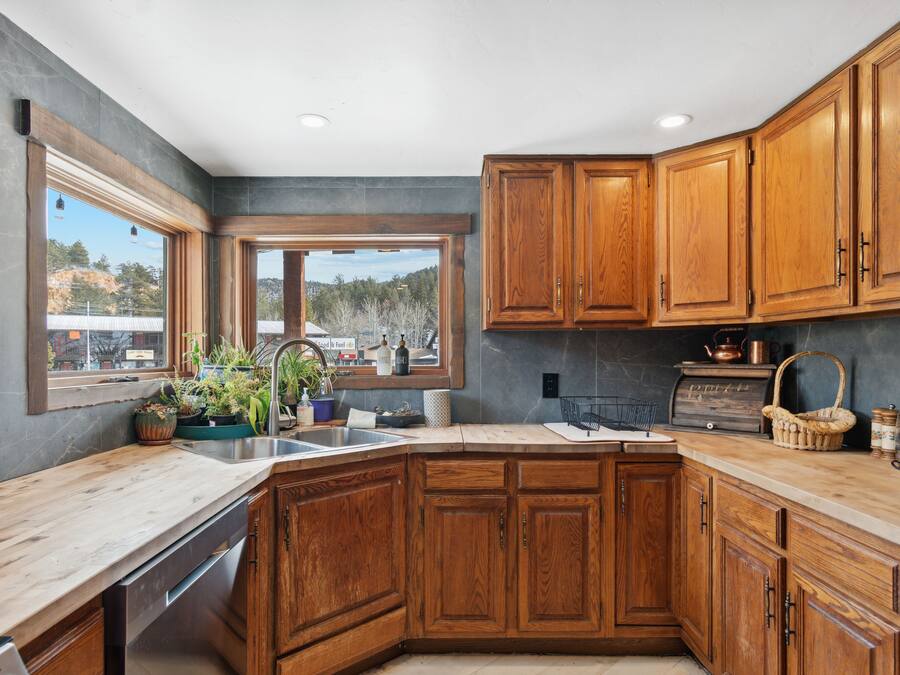 Una cocina con armarios de madera, un ventanal y vistas al exterior.