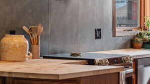 A modern kitchen with a large island, stainless steel appliances, and a window with a view. - Ferncliff Lodge (Allenspark)