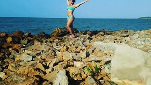 A person standing on rocky terrain by the sea. - Hostel La Casa Monocuco (San Antero)