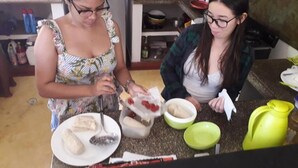 Two people preparing food in a kitchen with various utensils and containers on the counter. - Hostel La Casa Monocuco (San Antero)