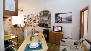 Ein gemütlicher Wohnbereich mit Essplatz, Küchenzeile und Fernseher.
