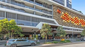Un hôtel moderne à la façade originale, ornée d’un motif géométrique composé d’hexagones orange et jaunes.