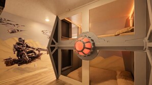 Quarto temático de Star Wars, com painel de parede, uma cama e estrutura de teto que lembra uma nave espacial.