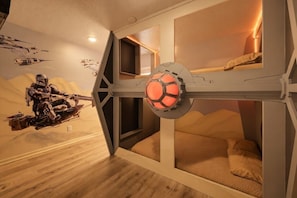 Una stanza a tema Star Wars, con un affresco, un letto e una struttura al soffitto che ricorda un'astronave.