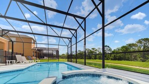 Uma piscina com hidromassagem, rodeada por uma estrutura metálica, e um edifício ao fundo.
