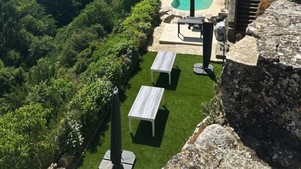 A pool area with a view of a river and forested hills. - Château d'Aiguèze (Aiguèze)