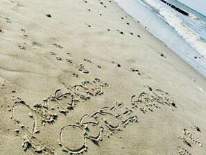 Footprints and a drawn heart on a sandy beach near the ocean. - Pension Ostsee-Strand (Boergerende-Rethwisch)